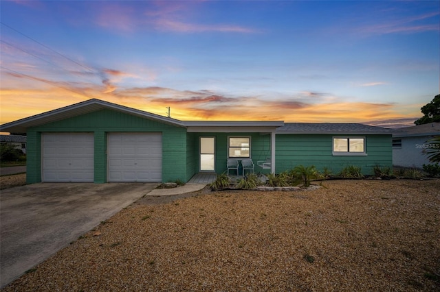 ranch-style home with a garage and covered porch