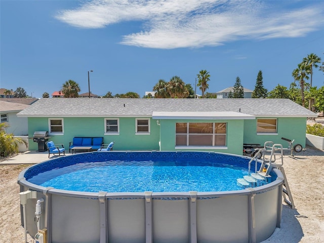 view of swimming pool featuring a grill and a patio area