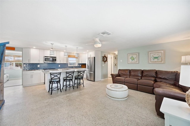 living room featuring ceiling fan and sink