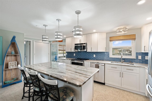 kitchen featuring backsplash, sink, stainless steel appliances, and white cabinets