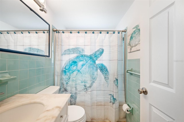 bathroom featuring a shower with shower curtain, toilet, vanity, and tile walls