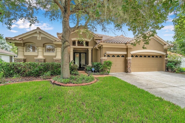 mediterranean / spanish-style home featuring a front lawn and a garage