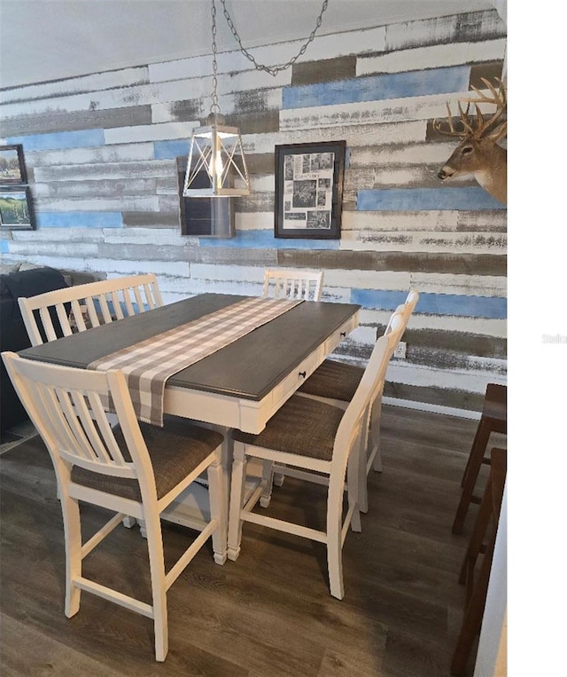 dining space featuring wood walls and dark hardwood / wood-style floors