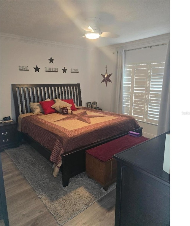 bedroom featuring ornamental molding, hardwood / wood-style flooring, and ceiling fan