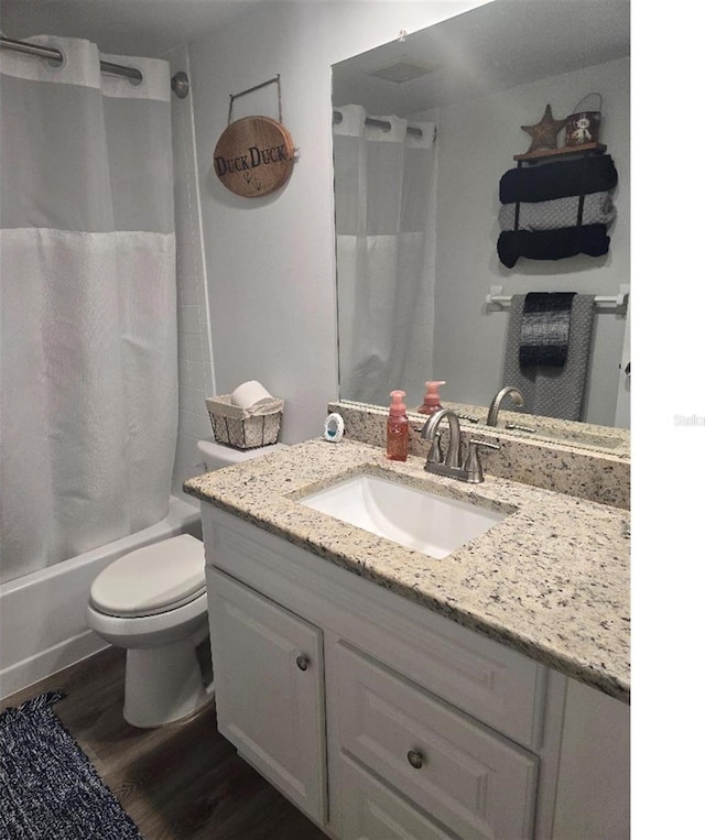 full bathroom featuring vanity, toilet, hardwood / wood-style flooring, and shower / bath combo