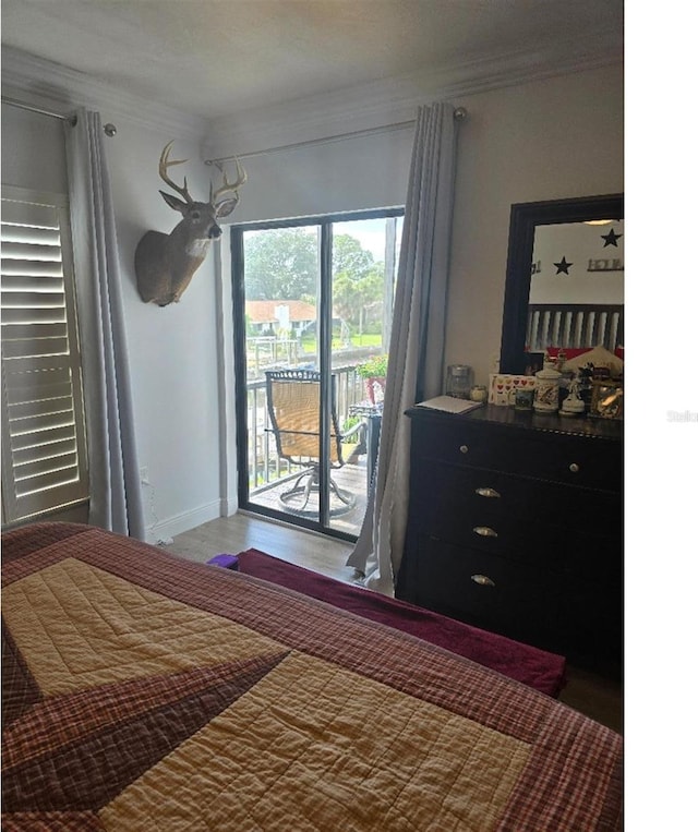 bedroom featuring hardwood / wood-style flooring, access to outside, and crown molding