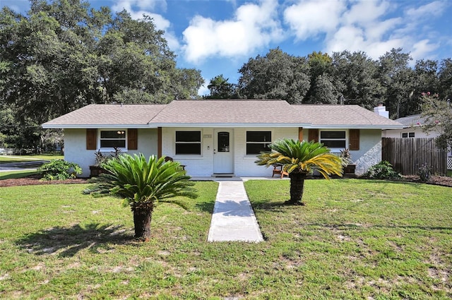 ranch-style house with a porch, fence, a front lawn, and brick siding