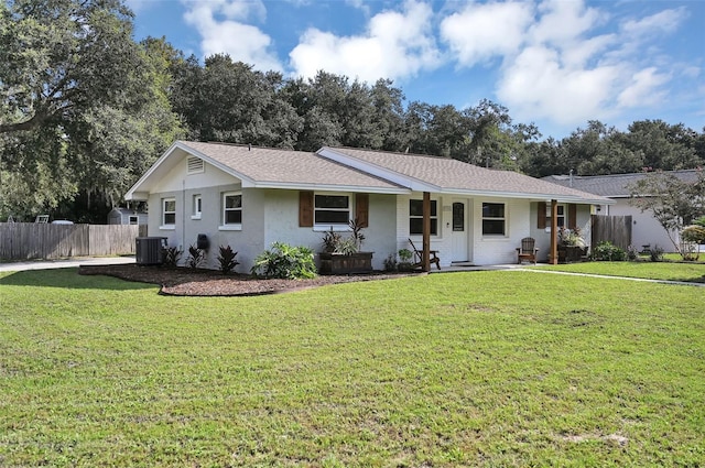 single story home featuring a porch, central air condition unit, fence, roof with shingles, and a front yard