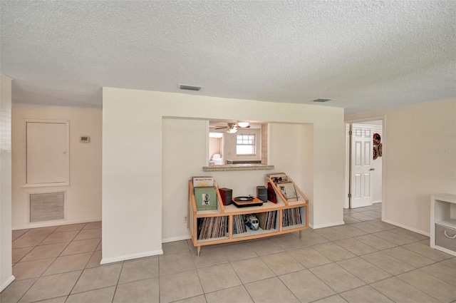 spare room featuring light tile patterned flooring, visible vents, and baseboards