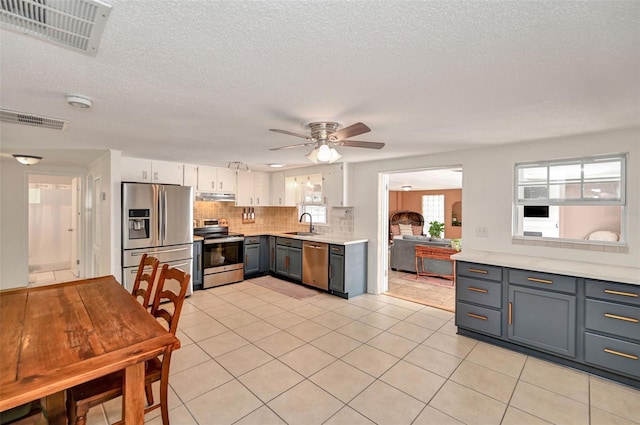 kitchen featuring appliances with stainless steel finishes, light countertops, visible vents, and decorative backsplash