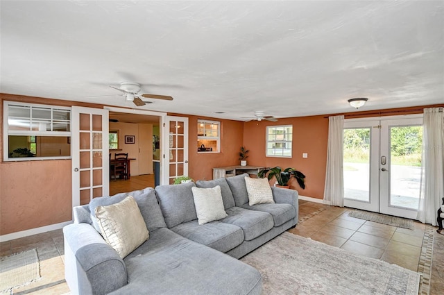 tiled living area featuring ceiling fan, french doors, and baseboards