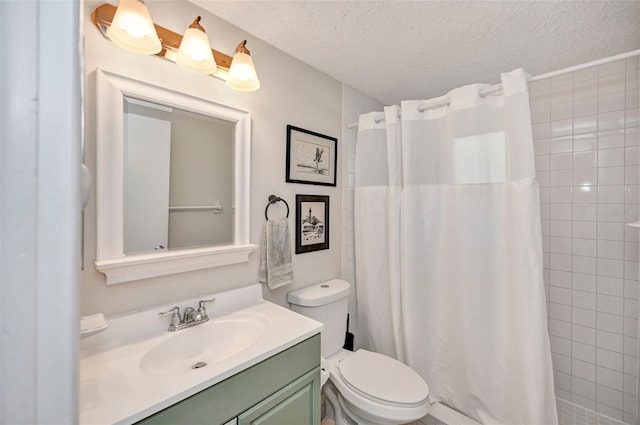 full bath featuring toilet, tiled shower, a textured ceiling, and vanity