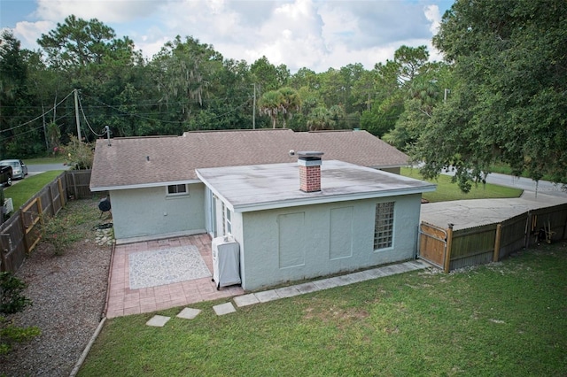 rear view of property with a yard, a fenced backyard, and stucco siding