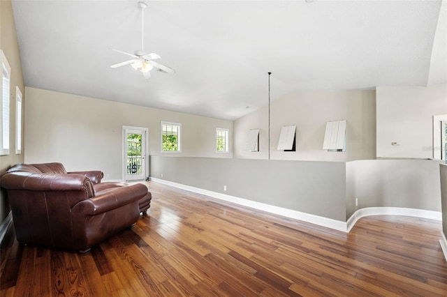 living area with ceiling fan, vaulted ceiling, and hardwood / wood-style flooring