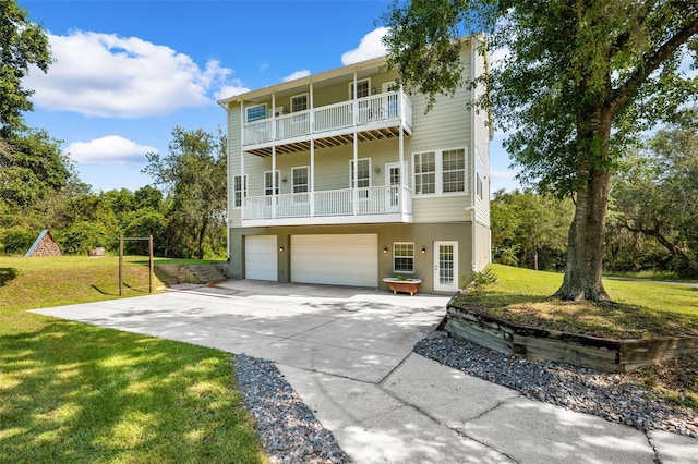 view of front facade featuring a balcony, a front lawn, and a garage