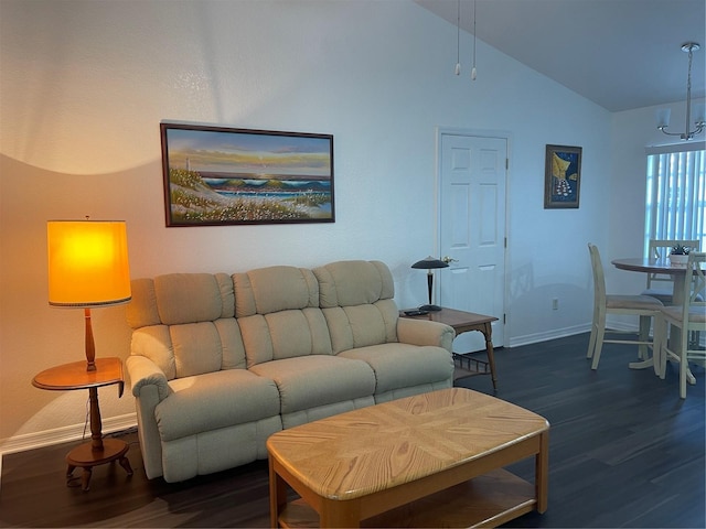 living room featuring dark wood-type flooring, vaulted ceiling, and a notable chandelier