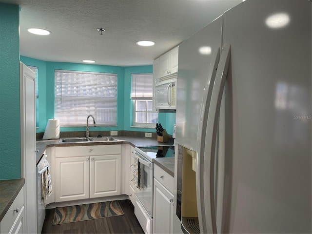 kitchen with washer / clothes dryer, sink, white cabinets, and white appliances