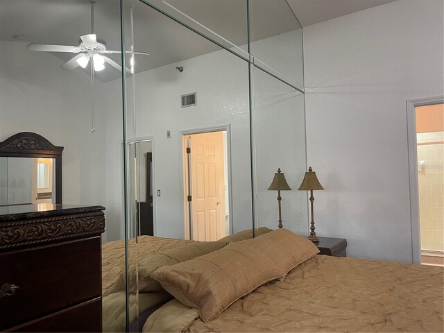 bedroom with a towering ceiling, connected bathroom, and ceiling fan