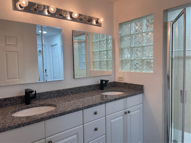 bathroom featuring vanity and a shower with door