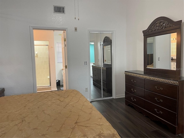 bedroom with ensuite bath, dark hardwood / wood-style flooring, and a closet