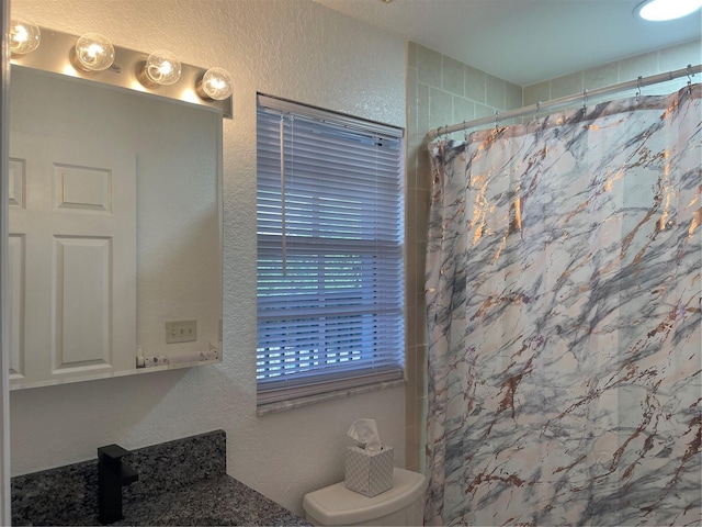 bathroom featuring vanity, a shower with shower curtain, and toilet