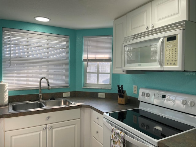 kitchen with white cabinetry, sink, and white appliances