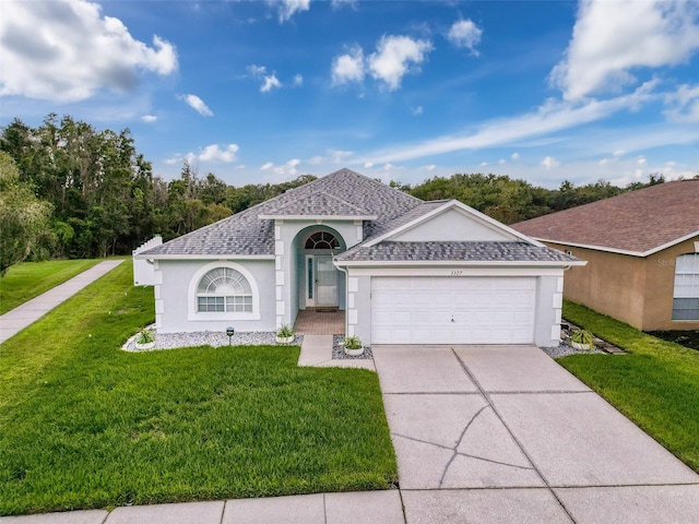 view of front of property featuring stucco siding, driveway, a front lawn, a shingled roof, and a garage