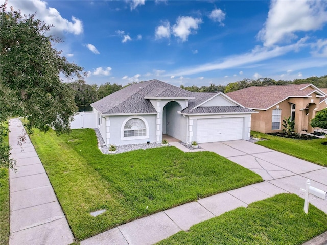 single story home with a front yard, an attached garage, driveway, and stucco siding