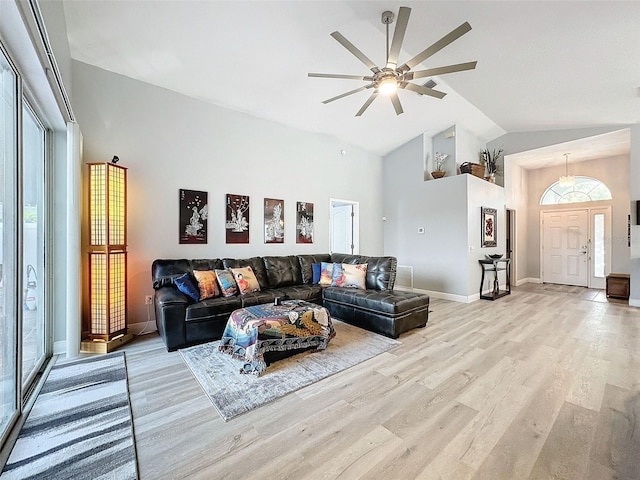 living area with ceiling fan, light wood-style flooring, baseboards, and high vaulted ceiling