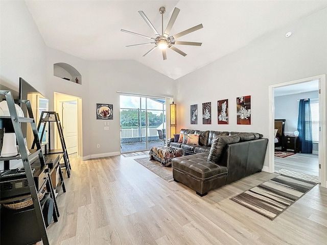 living room featuring light wood-type flooring, baseboards, high vaulted ceiling, and ceiling fan