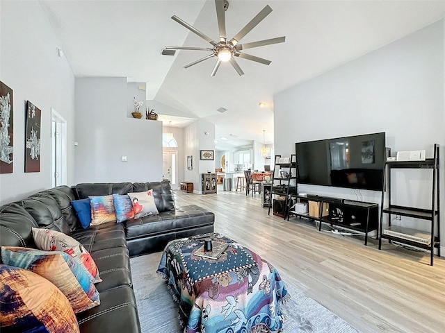 living area with high vaulted ceiling, ceiling fan, and wood finished floors