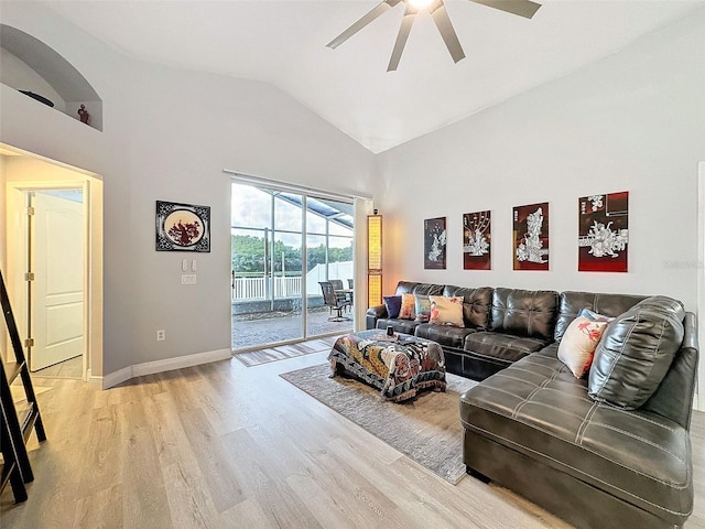 living room featuring ceiling fan, baseboards, light wood-type flooring, lofted ceiling, and a sunroom