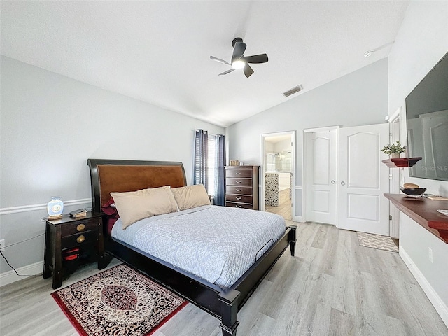 bedroom with visible vents, connected bathroom, light wood-style floors, ceiling fan, and vaulted ceiling