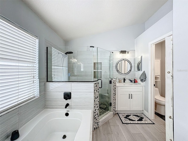 bathroom featuring a shower stall, toilet, vaulted ceiling, a bath, and vanity