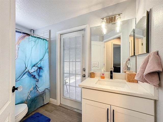 full bath with a shower with shower curtain, toilet, a textured ceiling, and vanity