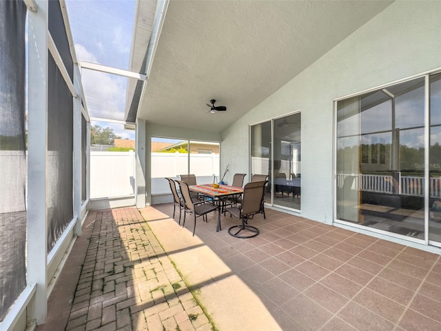 sunroom featuring lofted ceiling and a ceiling fan