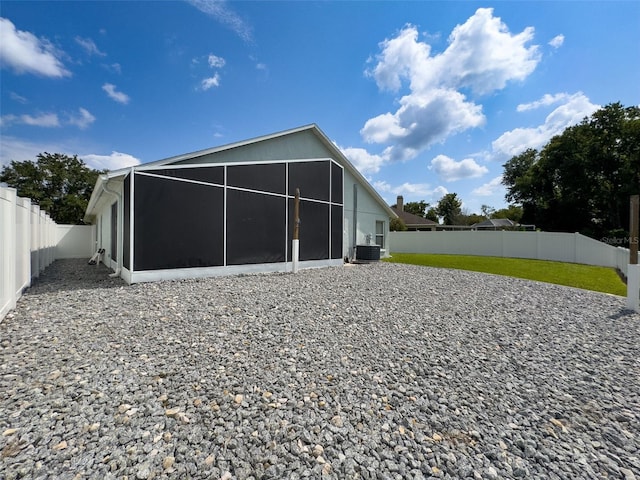 back of property with cooling unit, a fenced backyard, and a yard