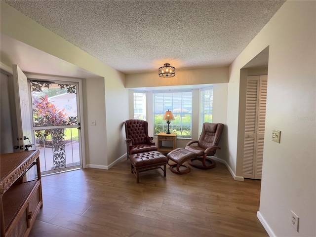 living area featuring a textured ceiling and hardwood / wood-style floors