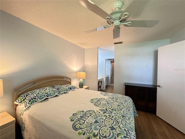 bedroom featuring ceiling fan, dark hardwood / wood-style flooring, a textured ceiling, and ensuite bath