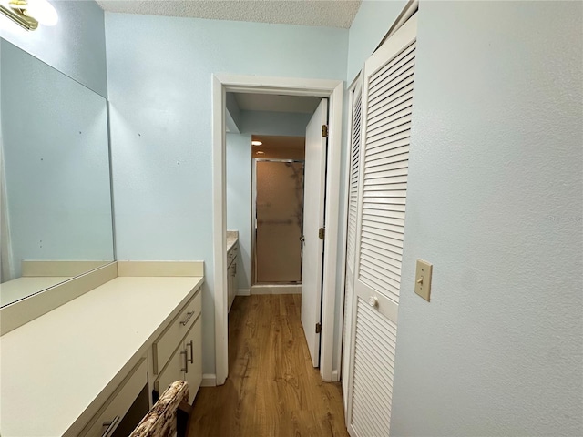 bathroom featuring a textured ceiling, hardwood / wood-style flooring, and vanity