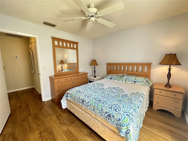 bedroom featuring ceiling fan, a textured ceiling, and hardwood / wood-style floors