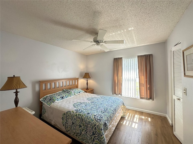 bedroom featuring ceiling fan, hardwood / wood-style flooring, a closet, and a textured ceiling