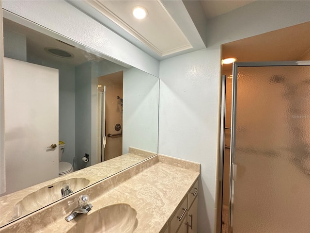 bathroom with a shower with door, vanity, and toilet