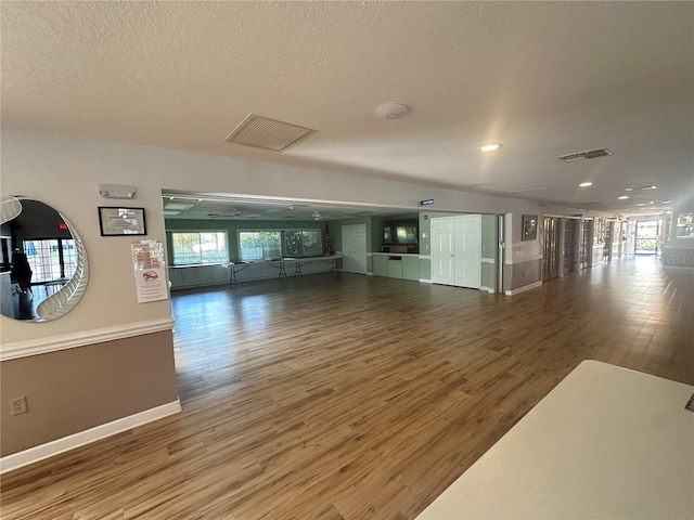 interior space with a textured ceiling and hardwood / wood-style floors