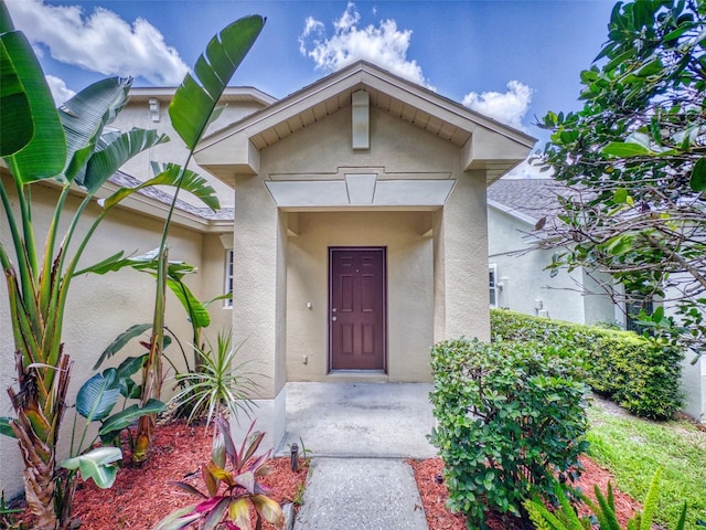 doorway to property featuring stucco siding