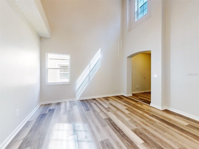 interior space with a towering ceiling and light wood-type flooring