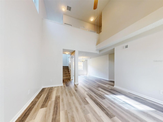 spare room featuring a high ceiling and light hardwood / wood-style floors