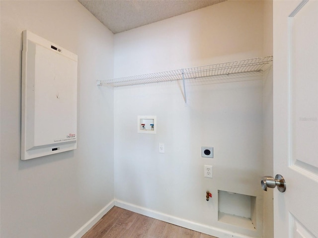 washroom with hookup for a washing machine, gas dryer hookup, hardwood / wood-style floors, hookup for an electric dryer, and a textured ceiling