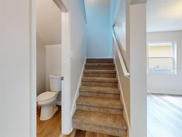 stairway featuring hardwood / wood-style floors and a textured ceiling