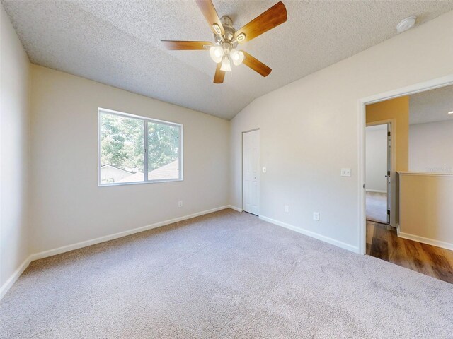 unfurnished bedroom featuring vaulted ceiling, a closet, wood-type flooring, ceiling fan, and a textured ceiling